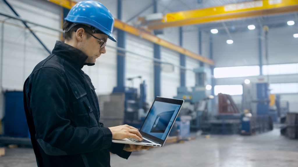 engineer ceckt zijn laptop om de data van de fabriek te controleren.